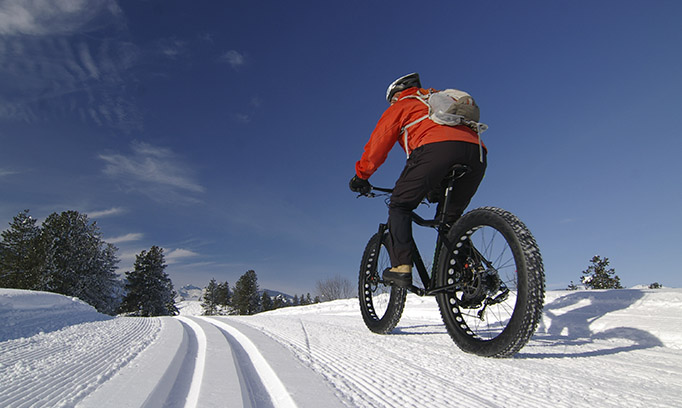 person riding bike on snow, winter workouts