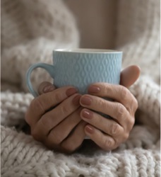 hands cradling coffee cup during cancer treatment