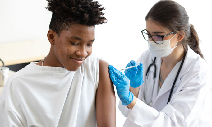 young African man getting a vaccine from doctor to build up or maintain immunity 