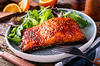 spicy dry rubbed baked salmon with side salad on white plate 1280536753