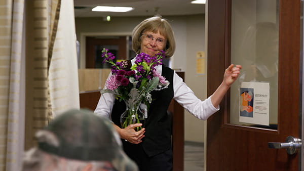 volunteer bringing flowers to a patient