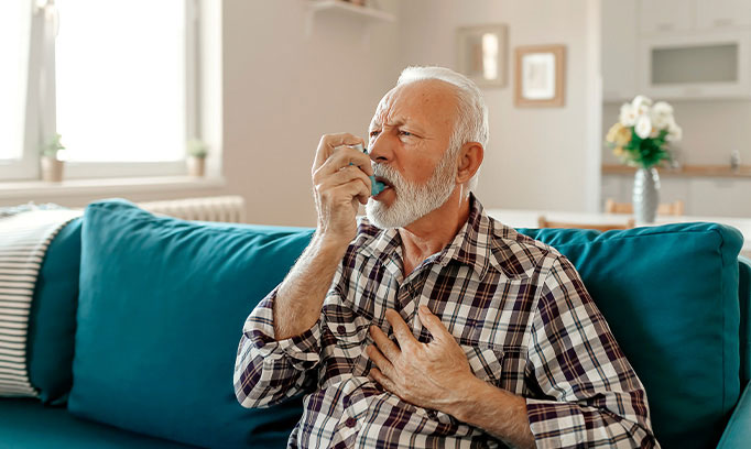 Man taking asthma medication through an inhaler