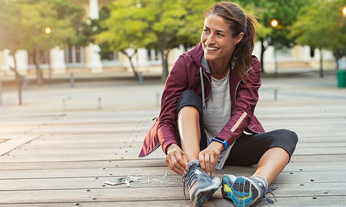 woman putting on running shoes 