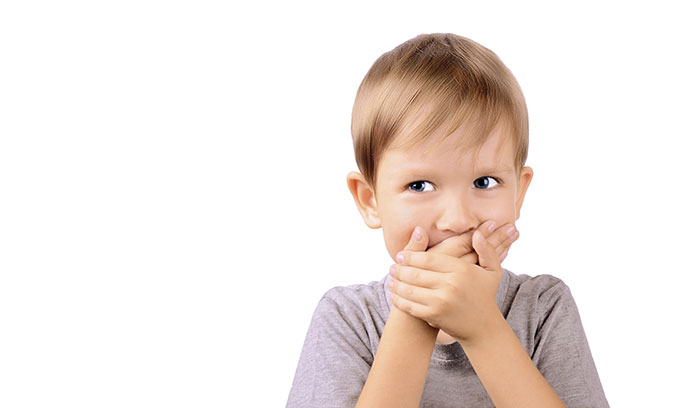 boy covering mouth because of bad breath 