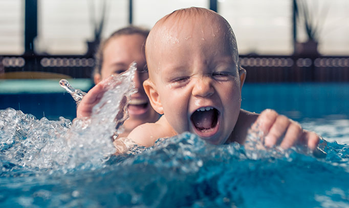 baby and mom splashing in pool 