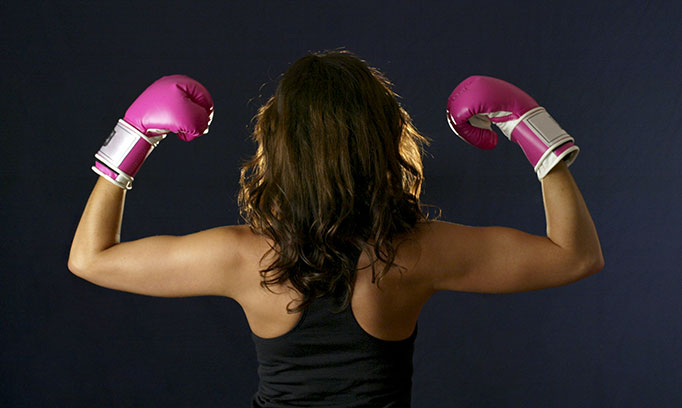 woman with boxing gloves to symbolize being empowered with information about breast cancer
