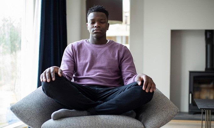 teen practicing meditation at home as a way to cope with coronavirus isolation