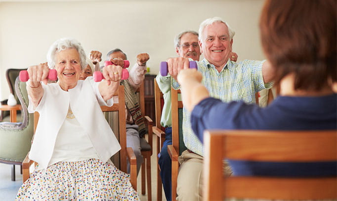 group of seniors strengthen their brains by weight training (lifting hand weights)