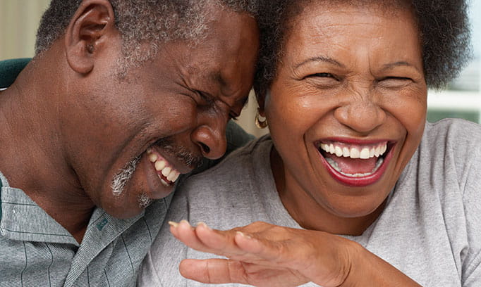 Middle aged man and woman laughing over stress incontinence, perhaps?