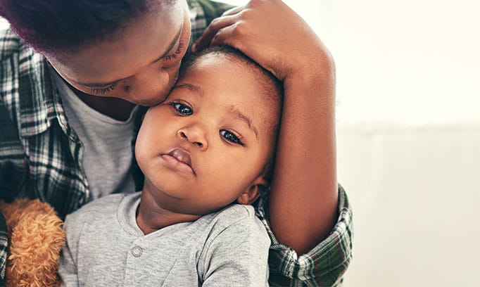 Parent caring for child suffering from symptoms of the kids common cold