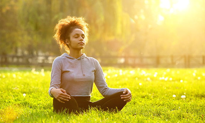 Woman using meditation and relaxation to reduce pain or stress