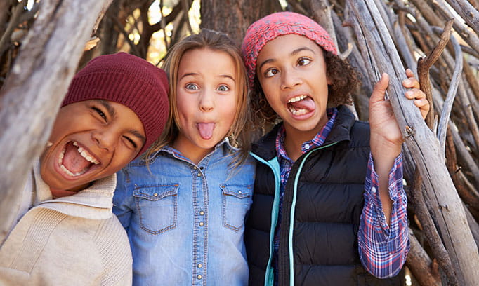 Three middle school kids who have been vaccinated for HPV act goofy for the camera