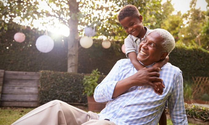 Smiling grandfather plays with his grandson
