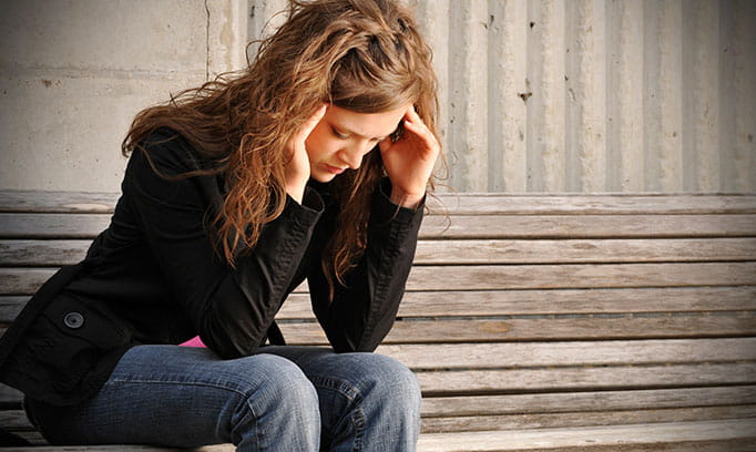 Woman with headache pain massaging her temples wondering what natural remedies for headaches she can use