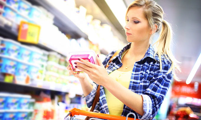 Woman reads a food label in a grocery store