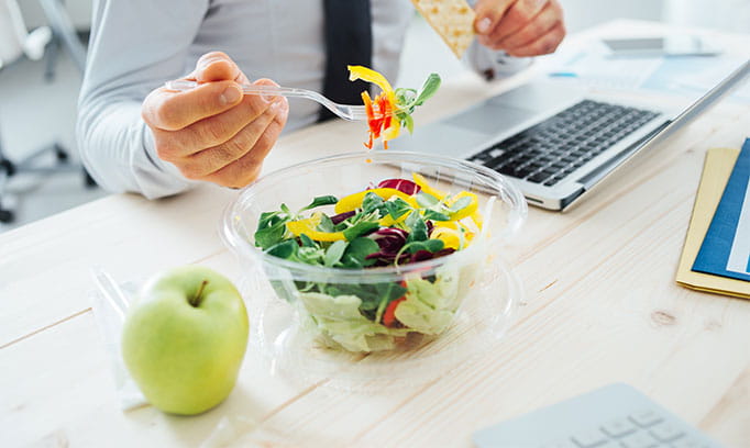 man at work eating a healthy lunch 