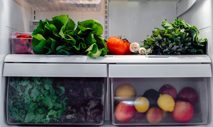 Refrigerator stocked with colorful, healthy fruits and vegetables