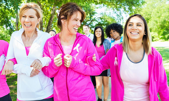 three women wearing pink are walking to combat chemo brain
