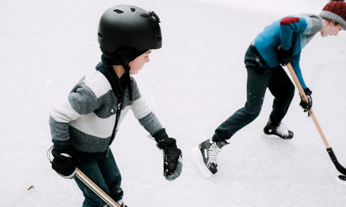 Young hockey player wearing helmet to protect against head injury.