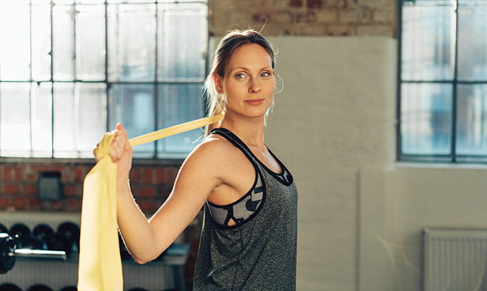 woman at gym with stretchy band for maintaining joint health 