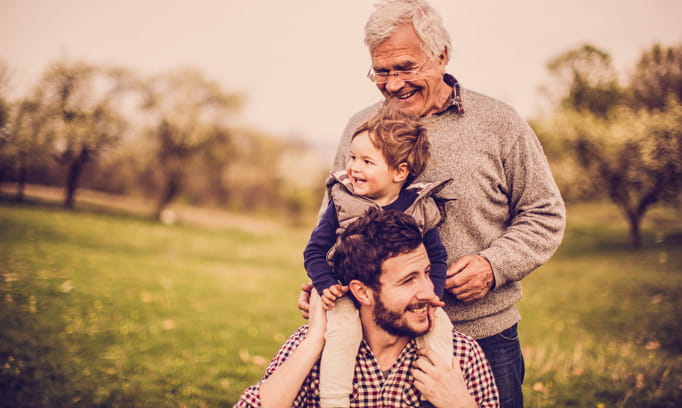 Grandfather, grandson and son enjoy each other's company outdoors