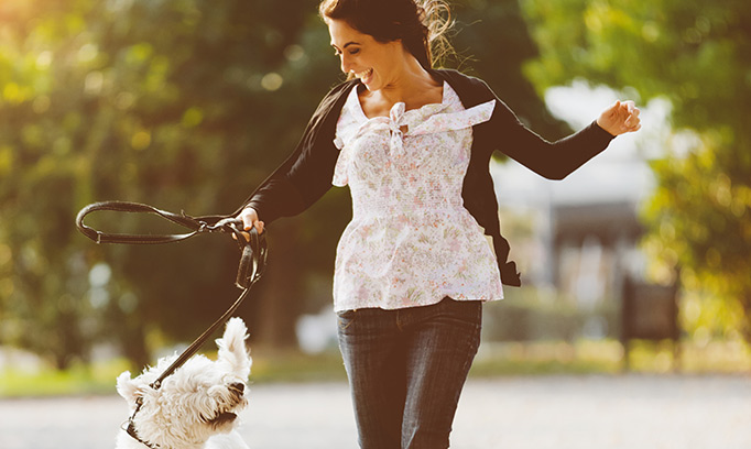 Woman smiling at her dog while out for a walk 