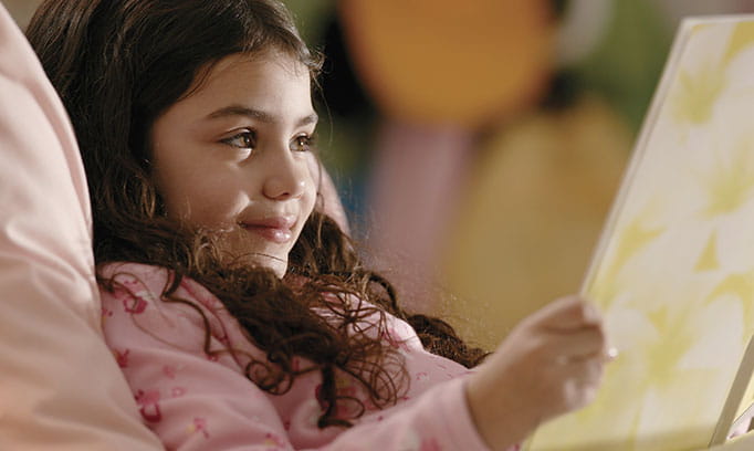 Girl gets settled in bed to prepare for the start of the school year