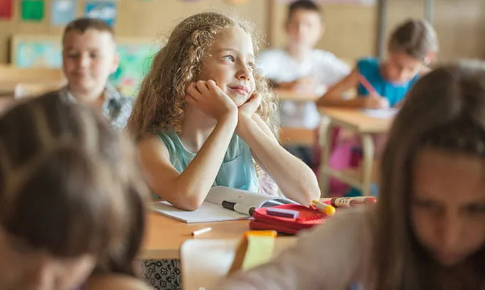 A young girl daydreaming in class