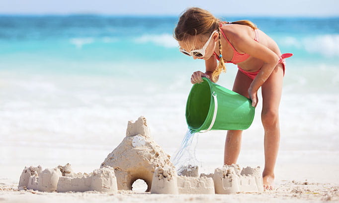 Girl at beach with sunglasses to protect eyes from UV light