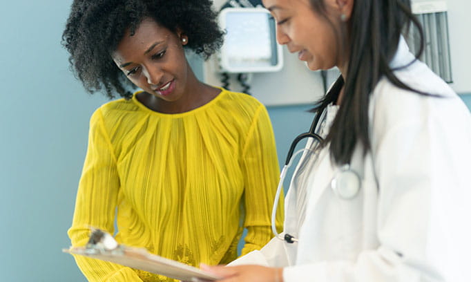 Woman discusses UTI symptoms and treatment with her doctor