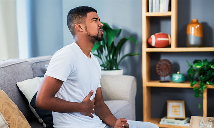 man with symptoms of GERD, holding stomach