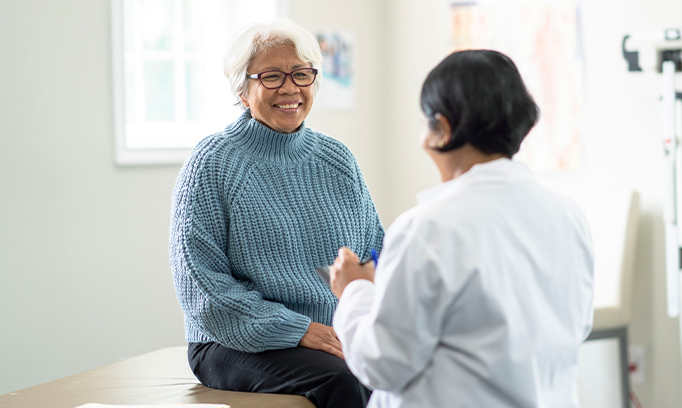 A primary care provider speaking with a smiling patient