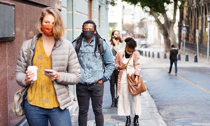 People social distancing in line wearing masks