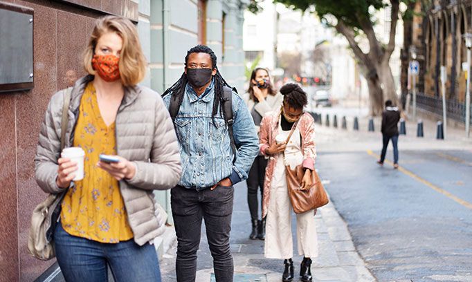 People social distancing in line wearing masks