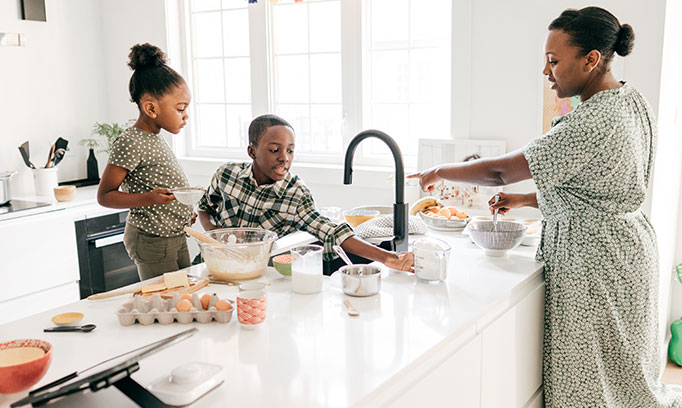 Mother preparing breakfast with her children because she knows the importance of eating breakfast