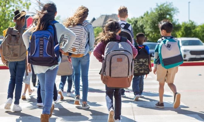 Kids walk to school after preparing for going back to school.