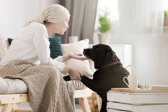 woman recovering from cancer spends quality time talking to and petting her black dog