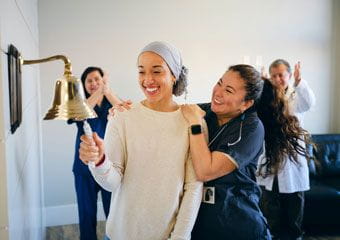 woman-ringing-bell-after-beating-cancer