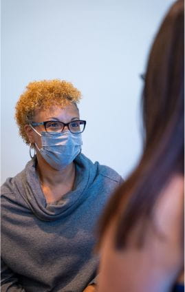breast cancer patient wearing mask learning about breast cancer symptoms