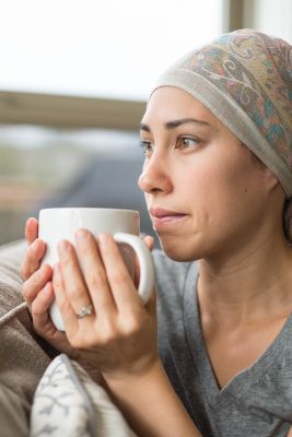 woman resting after having chemo, drinking a warm beverage to ease chemotherapy side effects
