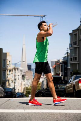athletic man walking and drinking water as part of a colon cancer regime