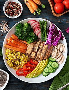 Plate filled with a colorful assortment of healthy foods including fruits, vegetables lean protein and grains.