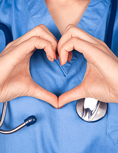 Healthcare professional forming a heart shape with hands to symbolize compassion and care.