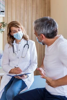 provider talking to patient about his colon pain and possible colon cancer symptoms