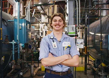 Allina team member standing among infrastructure equipment