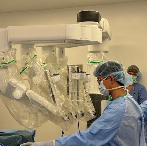 While robot with masked Dr. Lee at the controls