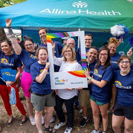 a group of Allina Health employees wearing all together better t-shirt at an event