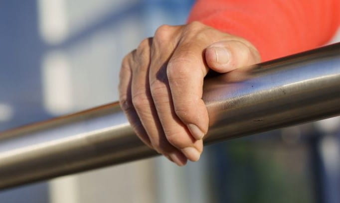 image of a hand holding onto a railing