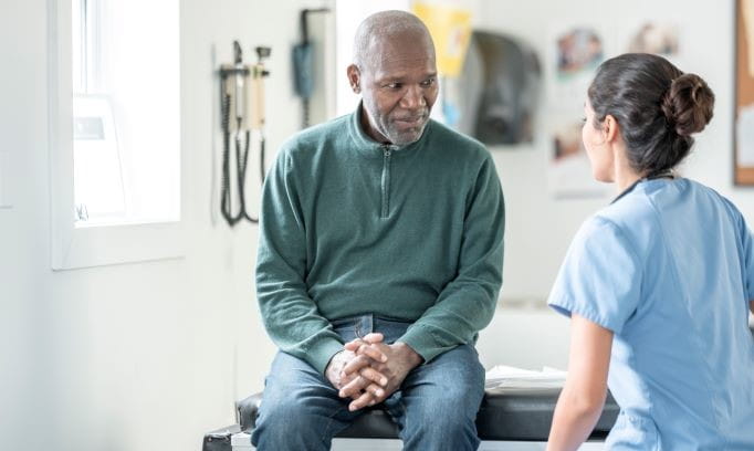 A older black male speaking with his doctor in a doctor's office