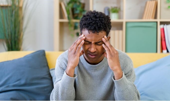 Person with headache shows warning signs that indicate a serious condition.